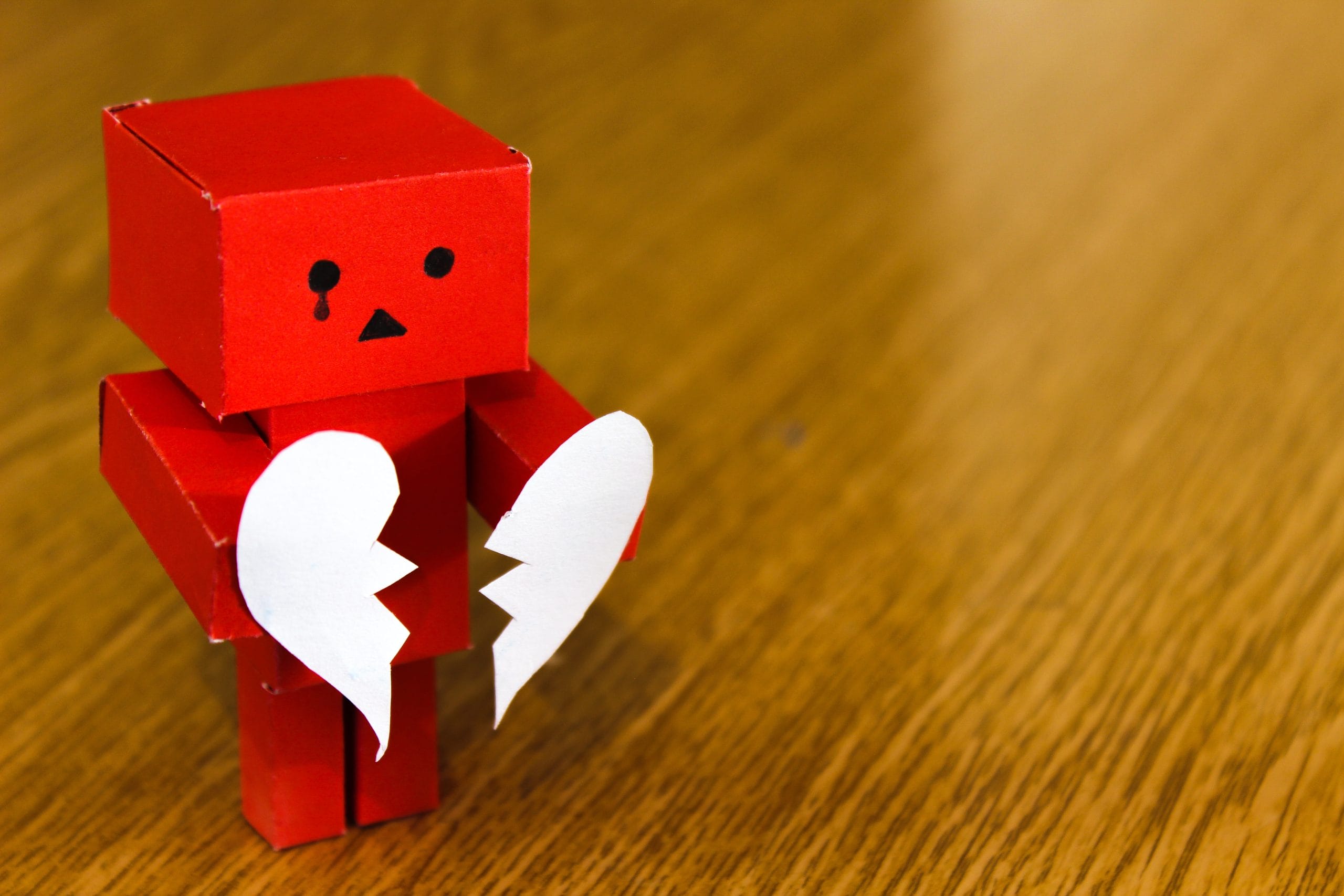 a paper robot holding a broken heart to symbolize the biggest networking mistakes