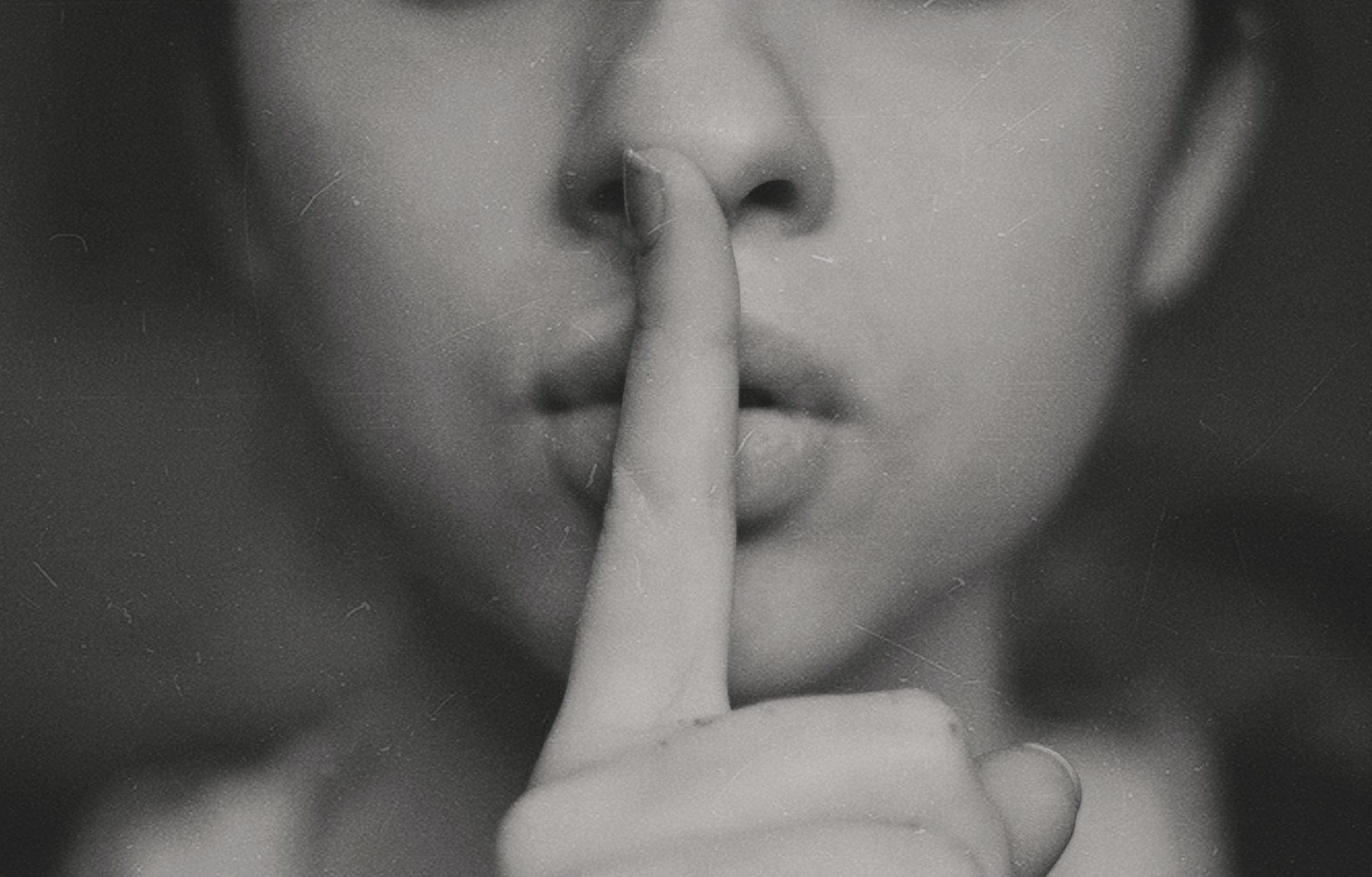 a woman with her finger on her lips to represent the secret of job hunting tips