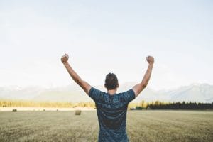 a man with his arms up in the air to represent getting un stuck in your career