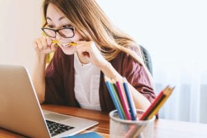 a woman biting her pencil in frustration