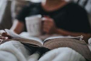 a woman reading with a cup of tea to represent getting headspace outside of work