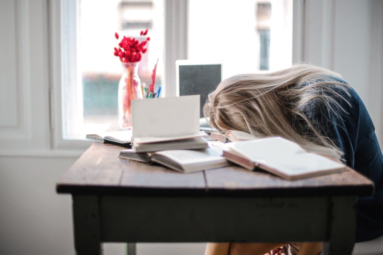 a woman asleep at her desk to symbolise why you need to prepare your virtual team for the long haul