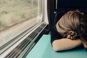 a woman sleeping on a train to represent burning out