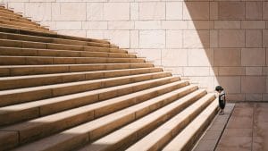 a little boy at the bottom of a large set of stairs