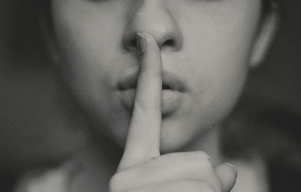 a woman with her finger on her lip to represent how to deal with difficult clients